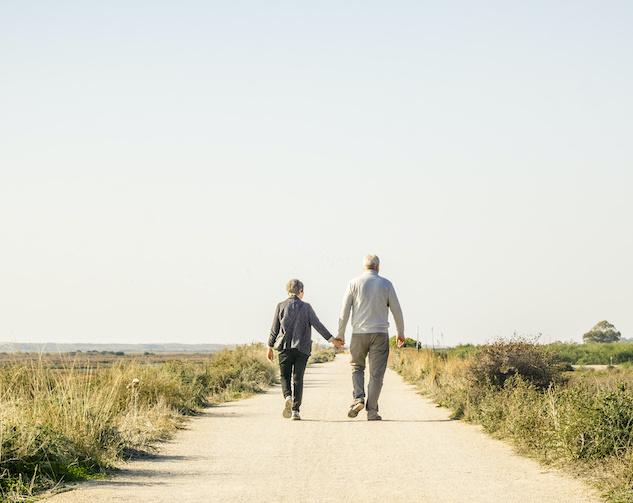 Elderly couple in love walking on a dust road, Portugal Elderly, healthy couple walking in Ria Formosa Park, Algarve, Portugal